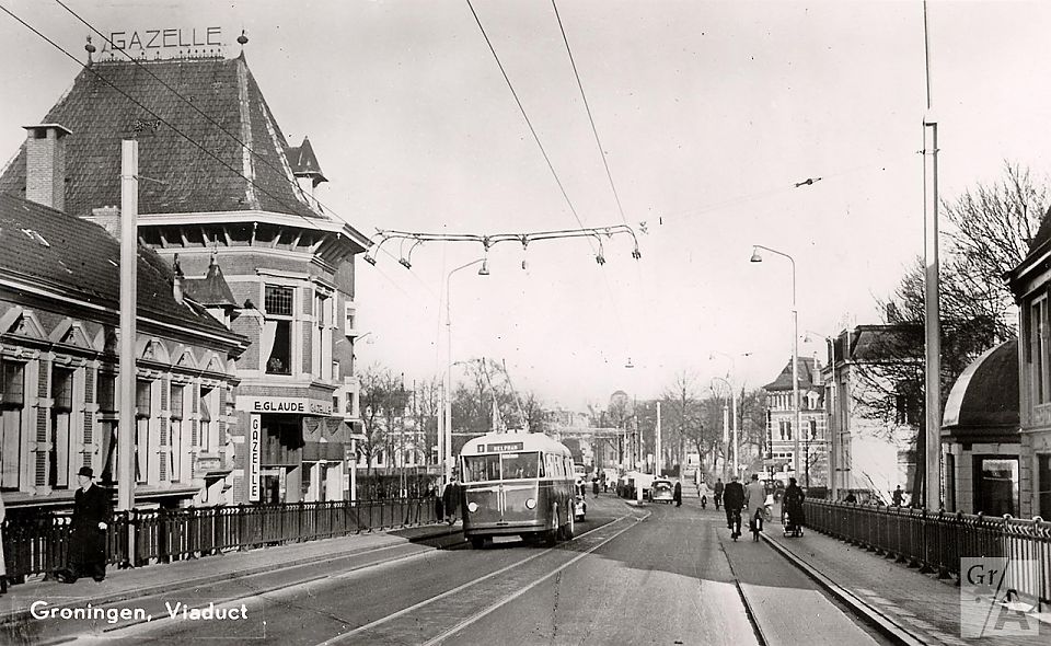 Ansichtkaart van omstreeks 1950 met het Herewegviaduct. Links staat de rijwielzaak van Glaudé. Collectie Groninger Archieven (1986_2766).